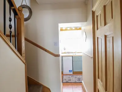 a hallway with a stairway leading to a kitchen at Cae Tanws Bach in Dolgellau