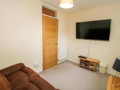 a living room with a couch and a flat screen tv at Bicton Lea in Acton