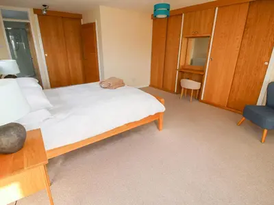 a bedroom with a large bed and a blue chair at Bicton Lea in Acton