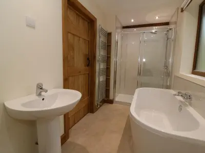 a bathroom with a sink and a tub and a toilet at Ploony Hill Lodge in Bleddfa