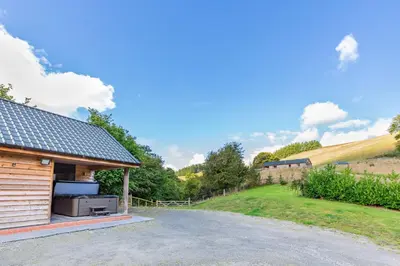 a cabin with a stove on the side of a road at Ploony Hill Lodge in Bleddfa