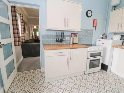 a kitchen with white cabinets and a stove at Dyffryn Bach in Rug