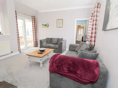 a living room with a couch and a table at Dyffryn Bach in Rug