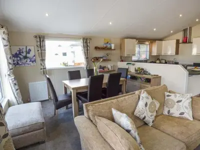 a living room with a couch and a table and a kitchen at Clearview Lodge in Borth