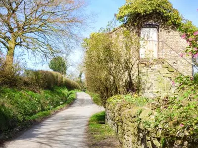 a dirt road next to a stone wall at Goosepond in Wistanstow
