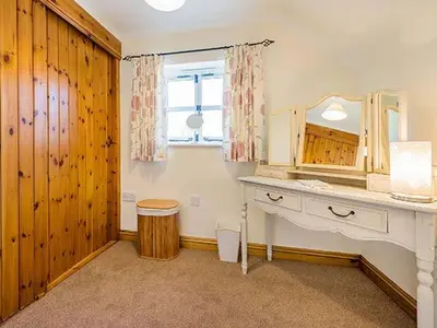a bathroom with a vanity and a mirror and a sink at Borrowers Cottage in Condover