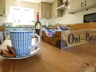 a coffee cup on a plate on a table in a kitchen at Gwdihw in Ifton Heath