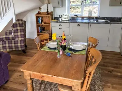 a wooden table with two plates and flowers on it at Gwdihw in Ifton Heath