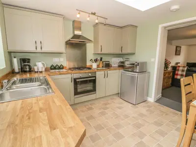 a kitchen with white cabinets and a counter top at Brickfield Cottage in Machynlleth