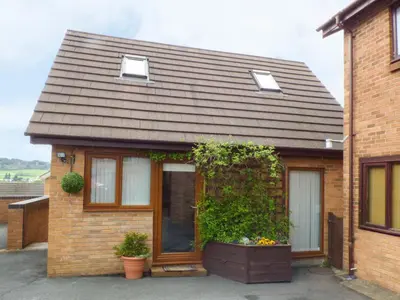 a brick house with a large window and plants at Penylodge in Builth Wells