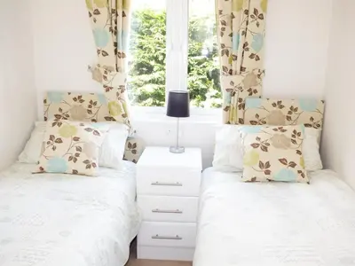 two twin beds in a bedroom with a window at 73-The Lodge in Llanina