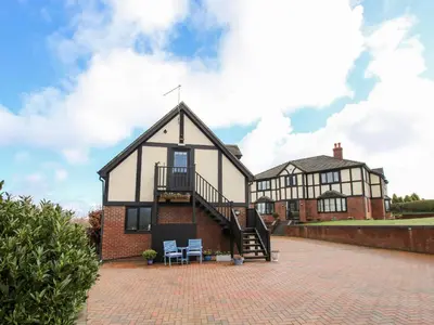 a large house with a staircase in front of it at The Wynnstead Annexe in West Felton