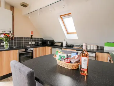a bottle of wine sitting on a counter in a kitchen at The Wynnstead Annexe in West Felton