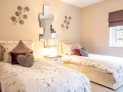 a bedroom with two beds and a window at Moelfre Cottage in Llanbedr