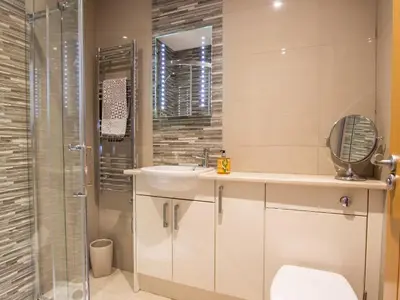 a bathroom with a sink and a toilet and a shower at Moelfre Cottage in Llanbedr