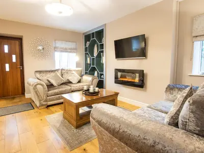 a living room with two couches and a fireplace at Moelfre Cottage in Llanbedr