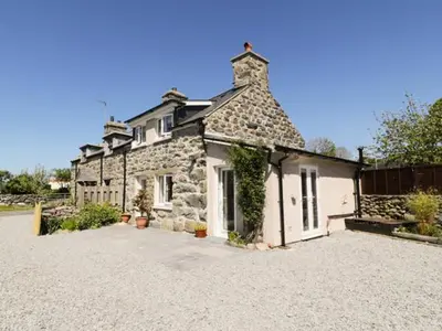 a large stone house sitting on top of a driveway at 2 Borthwen Cottages in Dyffryn