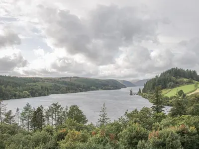a view of a river with trees and mountains at Little Beeches in Selattyn