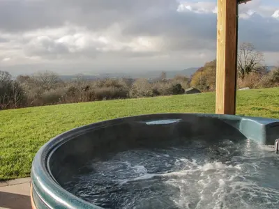a bath tub with water in it in a field at Stoney-Brook Lodge in Farden