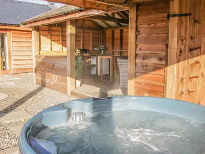 a hot tub in the backyard of a wooden cabin at Stoney-Brook Lodge in Farden