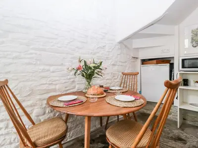 a kitchen with a wooden table with chairs and a dining room at 7 Bell Street in Talgarth