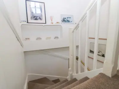 a stairway with white walls and white stairs with a stair case at 7 Bell Street in Talgarth