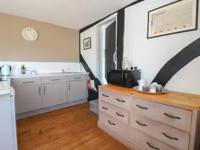 a kitchen with a dresser with a microwave and a sink at The Old Beams at Pont y Forwyn in Llansantffraid-ym-Mechain