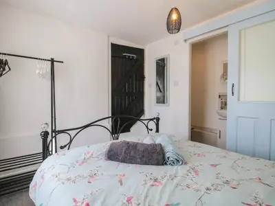 a bedroom with a bed with a pillow on it at The Old Beams at Pont y Forwyn in Llansantffraid-ym-Mechain