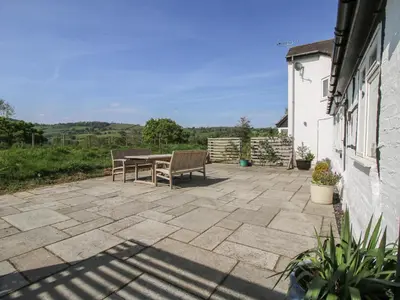 a patio with a table and two chairs on it at The Old Beams at Pont y Forwyn in Llansantffraid-ym-Mechain