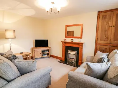 a living room with two couches and a fireplace at Llwyn Celyn in Llanfachreth