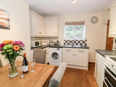 a kitchen with a table with a vase of flowers on it at Llwyn Celyn in Llanfachreth