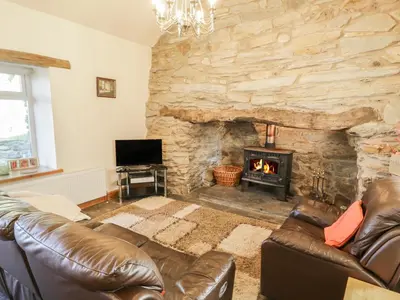 a living room with a couch and a fireplace at Yr Hen Dy in Ffestiniog