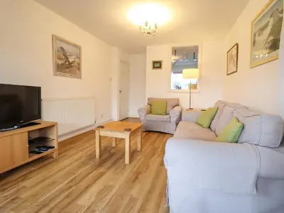 a living room with two couches and a tv at Dehangfa in Fairbourne