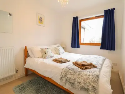 a bedroom with a bed with two towels on it at Dehangfa in Fairbourne