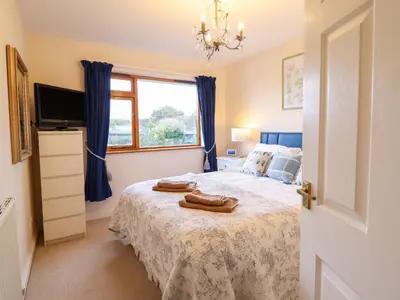 a bedroom with a bed with two towels on it at Dehangfa in Fairbourne
