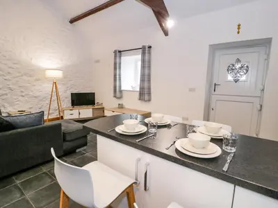 a kitchen and living room with a table and chairs at Cornel Glyd in Dyffryn