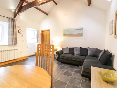 a living room with a couch and a table at Sisial-y-Mor in Dyffryn