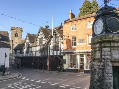 a building with a clock on the side of a street at Clun Forest Cottage in Monkhopton