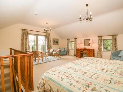 a bedroom with a bed and a dining room at Timber Barn in Eardisland