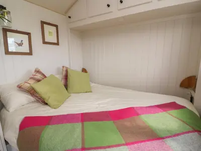 a bedroom with a bed with a colorful blanket on it at Shepherd's View in Saint Harmon