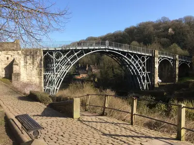 a bridge over a river with a bench on it at Ryelands Cottage in Easthope