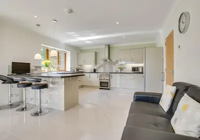 a kitchen and living room with a couch and a table at Bwthyn Bryn yr Aber in Bala