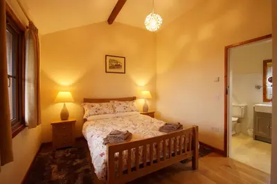 a small bedroom with a bed and a bathroom at Enlli Lodge in Llanddwywe