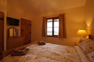 a bedroom with a large bed and a window at Enlli Lodge in Llanddwywe