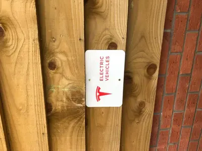 a white sign on a wooden fence at The Grange Guest House in Brecon