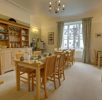 a kitchen and dining room with a table and chairs at The Grange Guest House in Brecon