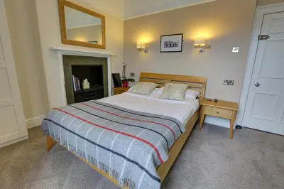 a bedroom with a large bed and a mirror at The Grange Guest House in Brecon