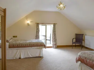 a attic bedroom with two beds and a window at No 1 Pegraig Draw - Uk6434 in Llanychaiarn