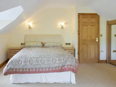a bedroom with a bed and a wooden door at No 1 Pegraig Draw - Uk6434 in Llanychaiarn