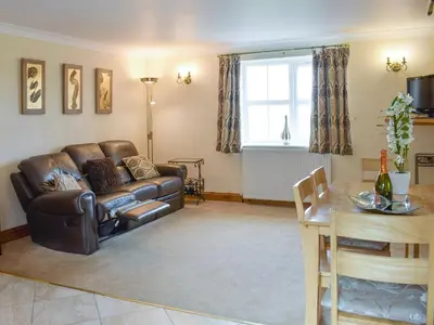 a living room with a leather couch and a table at No 2 Pegraig Draw - Uk6435 in Llanychaiarn